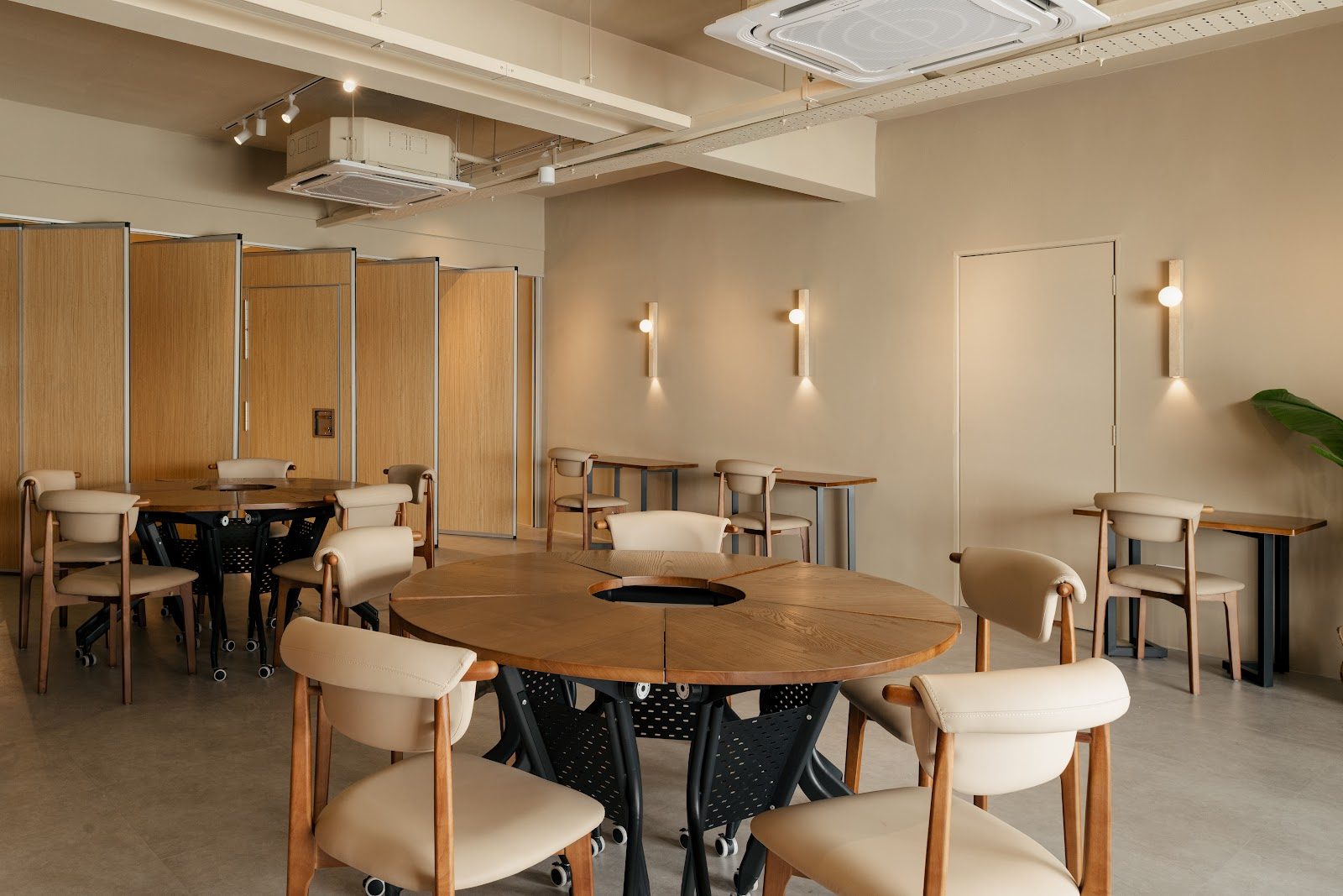 Round banquet tables set for a dinner in Amani Hall, The Timber Space